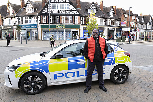 Ade Adeyemo standing in front of a WM Police car