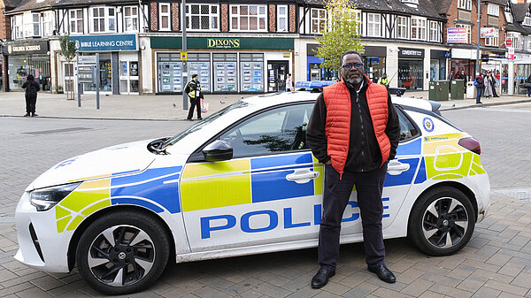 Ade Adeyemo standing in front of a WM Police car