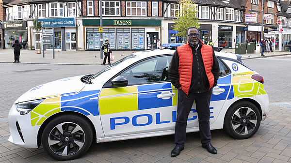 Ade Adeyemo standing in front of a WM Police car